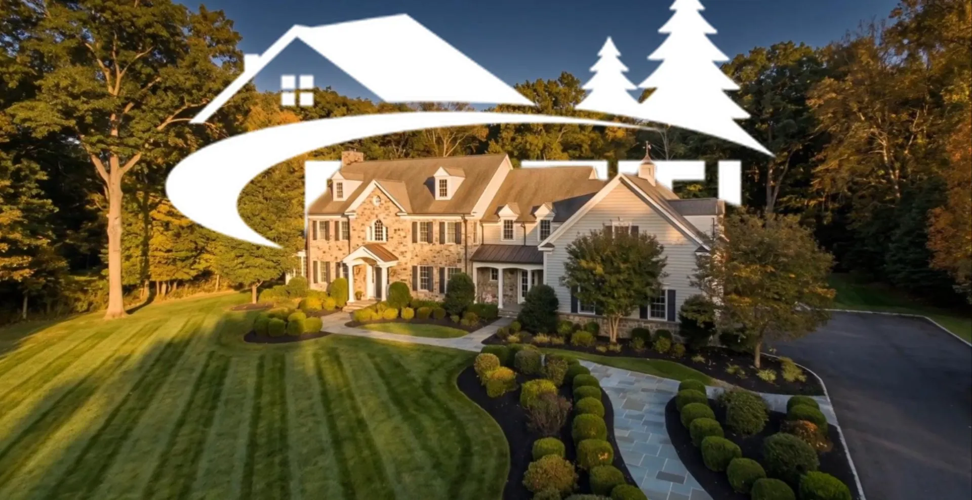 Aerial view of a striped lawn, boxwood beds and a stone colonial home in Bernardsville NJ maintained by Botti Home Services